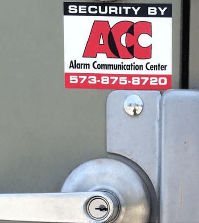 Alarm Communications sticker above a door handle